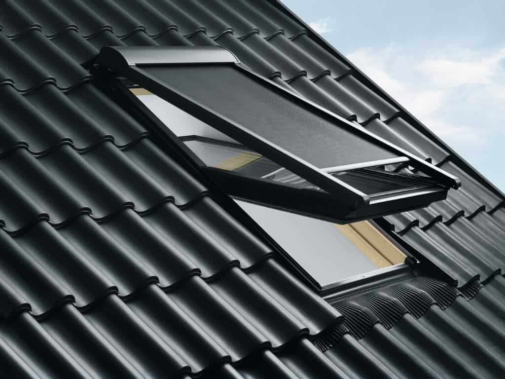 Dachfenster Muenchen schwarzes Ziegeldach mit VELUX-Dachfenster Schwingfenster geoeffnet und Himmel