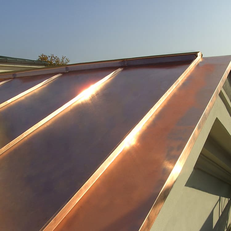Leistungen Dach neues Kupferblechdach Giebelseite an bestehendem hellgelbem Gebäude