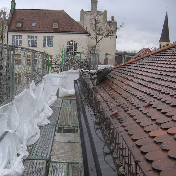 Dachdeckerei München altes Ziegeldach mit Biberschwanzziegel und Schneefanggitter nach Sturmschaden