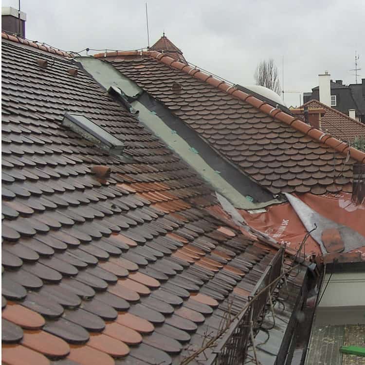 Dachdeckerei München altes Ziegeldach mit Biberschwanzziegel mit Baugerüst nach Sturmschaden