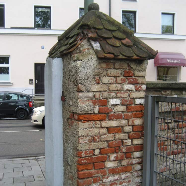 Dachdeckerei München alte unverputzte gemauerte Eingangssäule mit kaputtem Ziegeldach am Friedhof