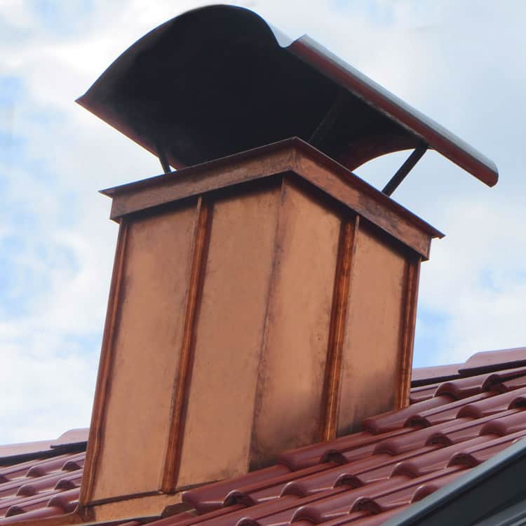 Spengler München Kamin mit Kaminverkleidung Kupfer mit Kaminhaube Ziegel Dach weiß-blauer Himmel