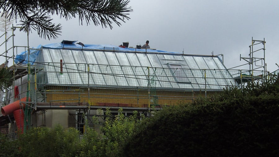 Spengler München bei Dacharbeiten auf Zink Metalldach mit Baugerüst an großem Gebäude