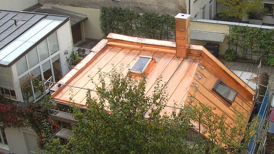 Spengler München Draufsicht auf das neue Kupferblechdach mit neuem Dachfenster und Kamin