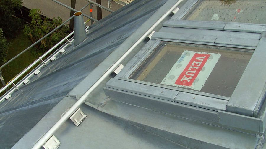 Spengler München auf Blechdach silber VELUX-Dachflächenfenster mit Schriftzug VELUX rot-weiß